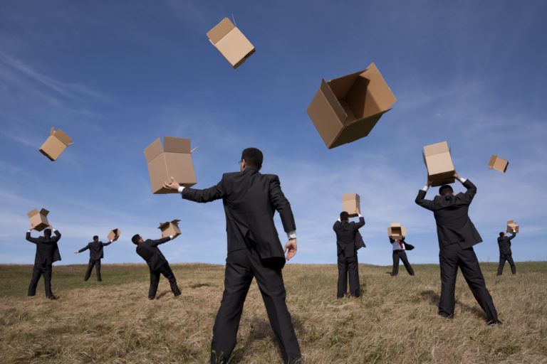 businessmen throwing empty boxes around an empty field